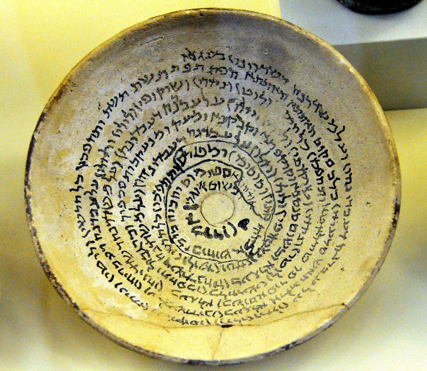 An earthenware bowl written over in spiralling Aramaic script, from Babylon, fourth to seventh century AD.