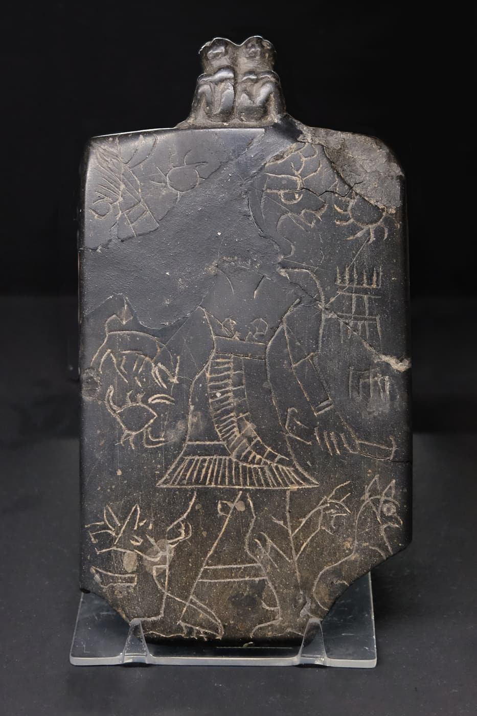 A dark stone plaque incised with figures, made to turn away the demon Lamashtu.